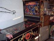 Picture of a pinball machine. The player is on the left, and the backglass can be seen to the right.